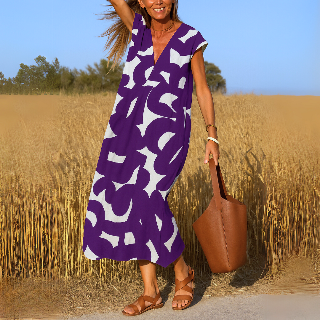 Valérie lightweight V-neck dress by The Rowan Daughters, featuring a flowing fabric and elegant design on a hanger.
